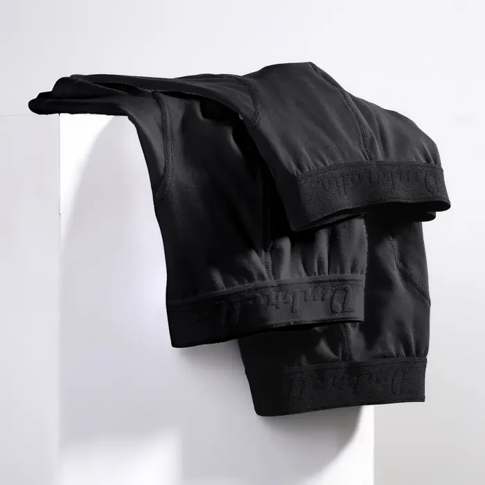 3 schwarze Baumwoll Unterhosen hängen über einer Wand