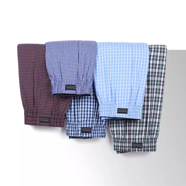 5 Boxershorts in verschiedenen Farben und Mustern hängen über eine Wand.